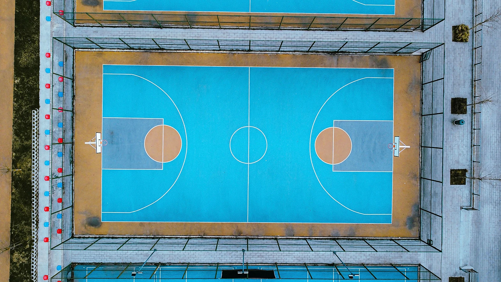 Natural outdoor acrylic sports court with blue surface and white line markings