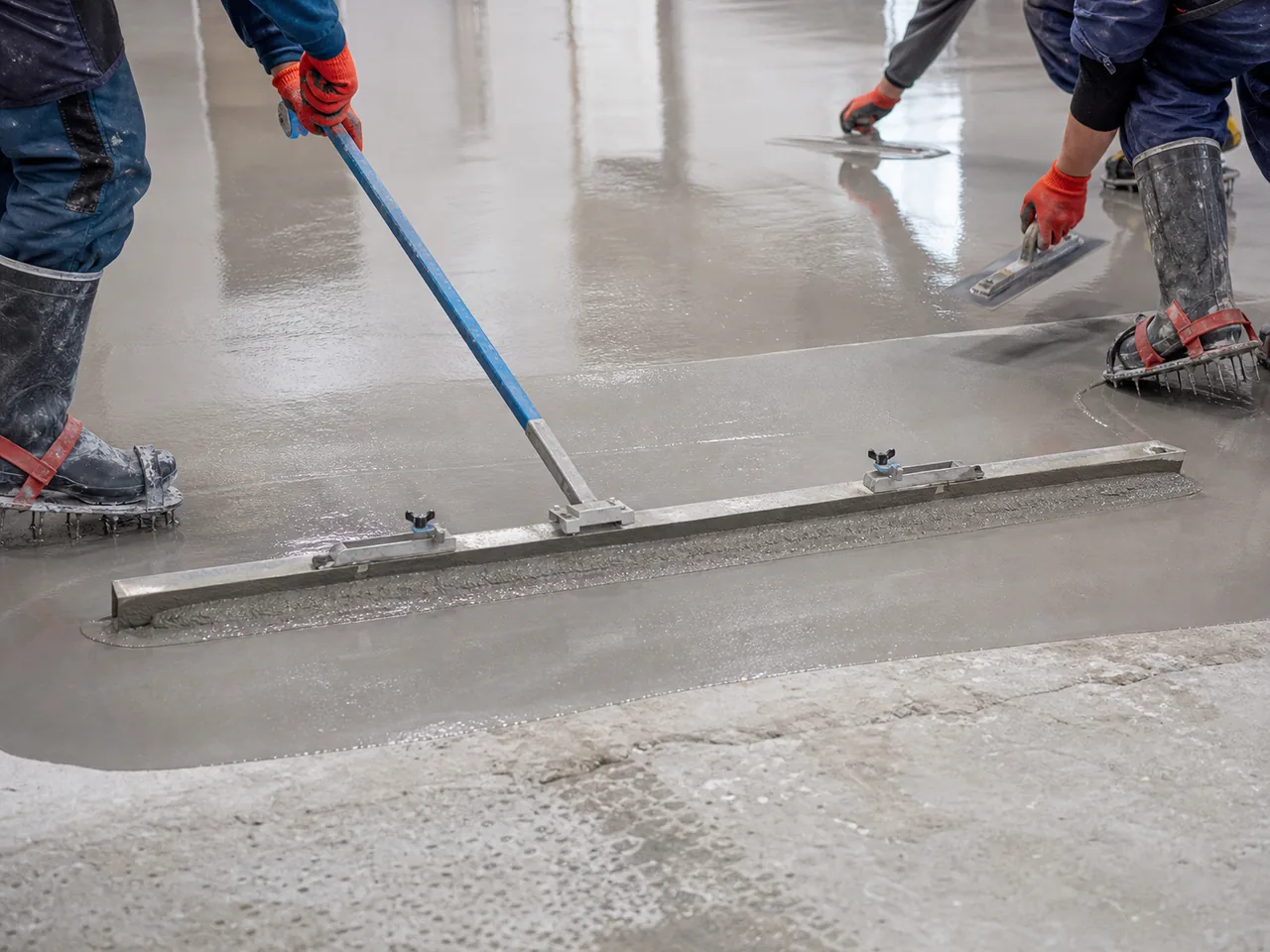 Industrial resin flooring installation process with screed and trowel application in KSA