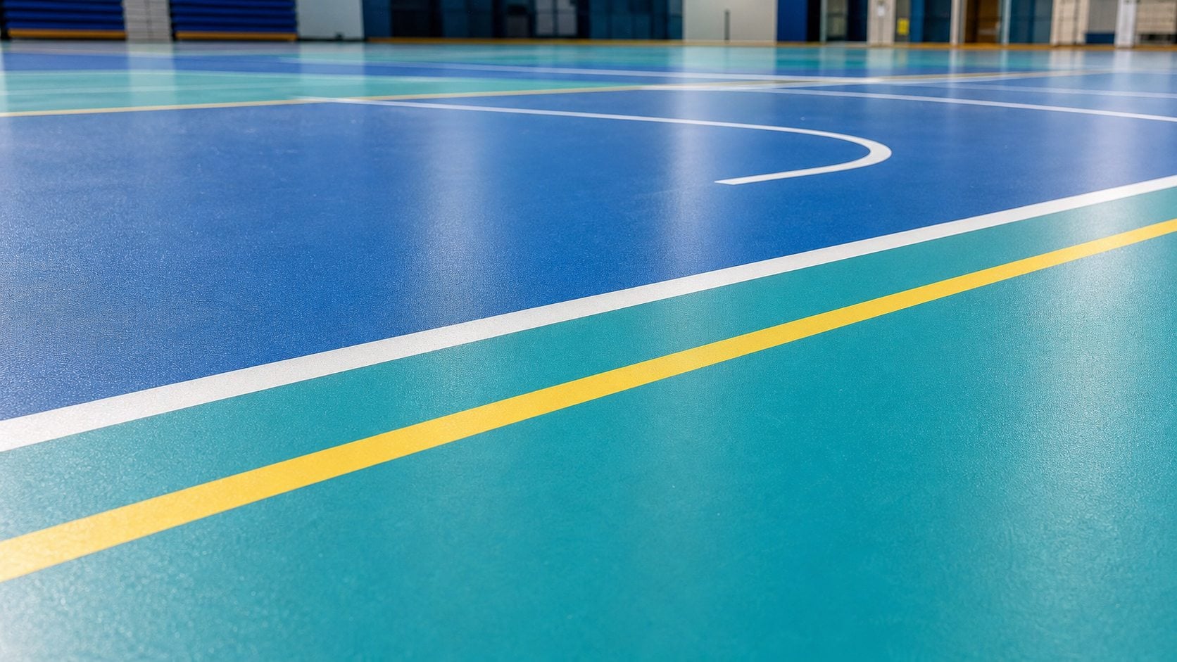 Indoor PU sports flooring with blue and teal court areas and white yellow line markings in Saudi Arabia