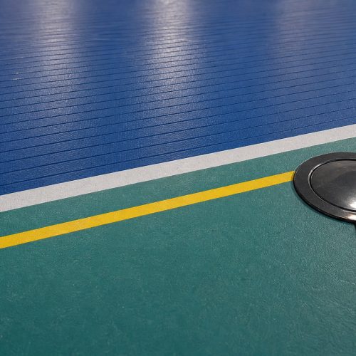 Natural indoor sports flooring with blue ribbed surface teal court area white and yellow lines in Saudi Arabia